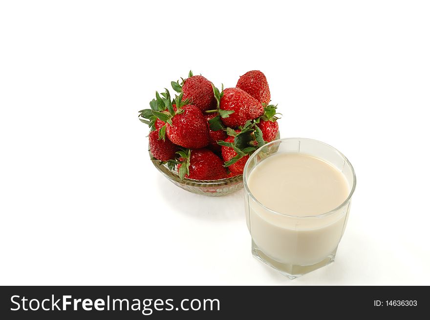 A glass of milk with ripe strawberries isolated on white background