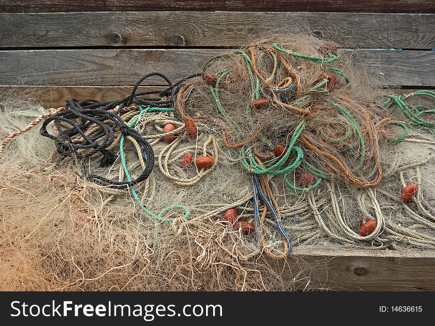 Heap of fishing nets with ropes and floats.