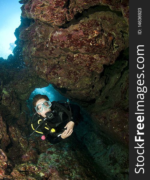 Scuba diver swimming through a cave