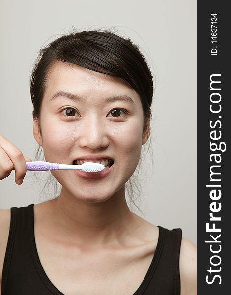 Attractive young woman brushing her teeth. Attractive young woman brushing her teeth