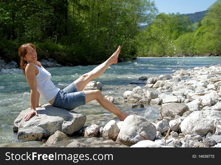 A woman enjoys the cooling on a cold River. A woman enjoys the cooling on a cold River.