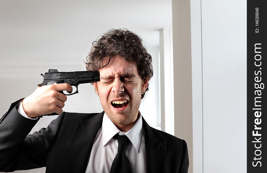 Businessman pointing a gun against his head. Businessman pointing a gun against his head