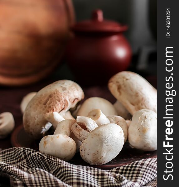 Fresh champignon mushrooms group on the table. Fresh vegetables mushrooms - the concept of healthy proper nutrition. Dark Food Photography - Image