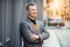 Free Handsome Smiling Young Adult Businessman Standing Outdoors Near Wall On City Street. Royalty Free Stock Photography - 146349087