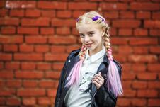 Close Up Portrait Of Little Beautiful Stylish Kid Girl Near Red Brick Wall As Background Stock Photo