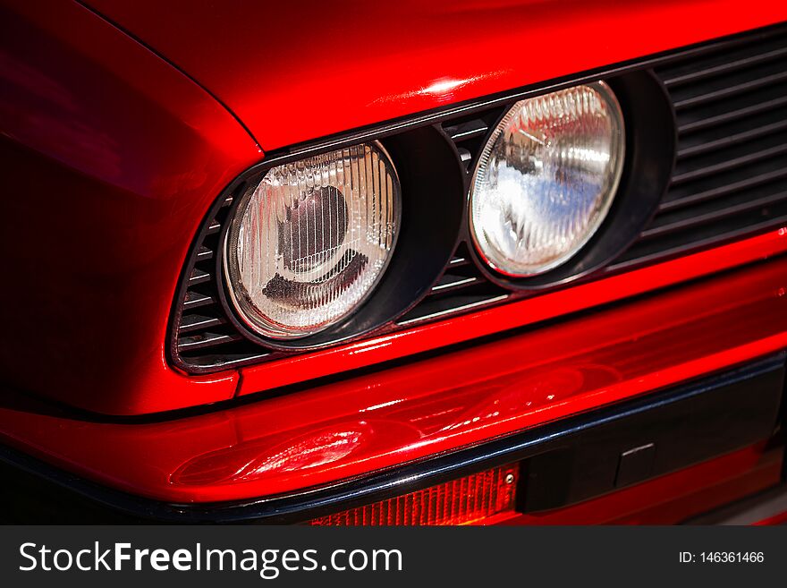 Headlights of a red, old, retro car, closeup.