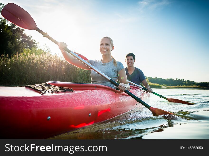 Confident Couple Paddling Over Lake