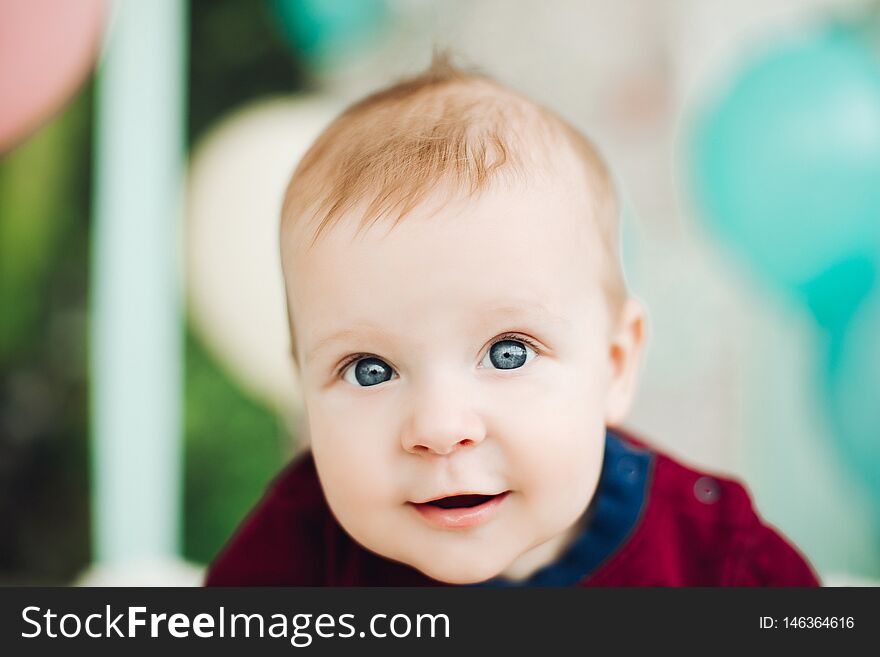 Sweet baby boy with big blue eyes lying on belly and smiling.