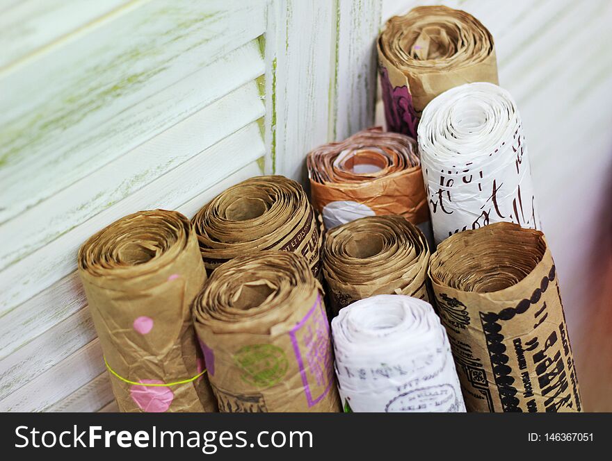 Kraft paper in rolls with vintage pattern for gift wrapping on the background of old painted blinds. Kraft paper in rolls with vintage pattern for gift wrapping on the background of old painted blinds