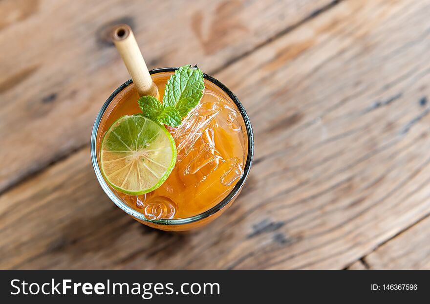 Ice cold sweet lemon tea drink  on the wooden table with outdoor sun lighting