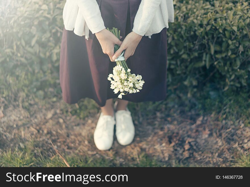 Hipster woman with a bouquet of snowdrops on the background of a natural parkland. Hipster woman with a bouquet of snowdrops on the background of a natural parkland