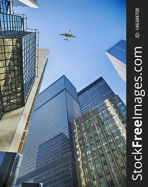 An airplane flies overhead Toronto skyscrapers. Skyscrapers in the financial district in downtown Toronto, Ontario, Canada