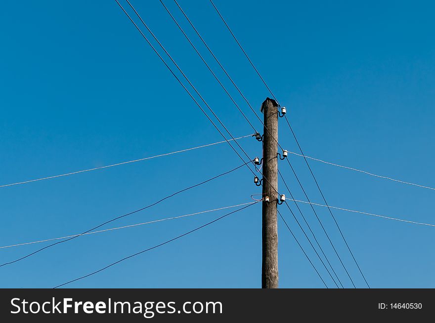 Electric wires are stretched every which way from a column