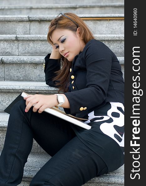 Beautiful blonde girl are reading on the stairs