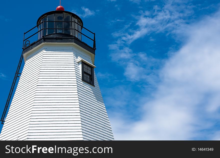 Close up on a lighthouse against the blue sky.