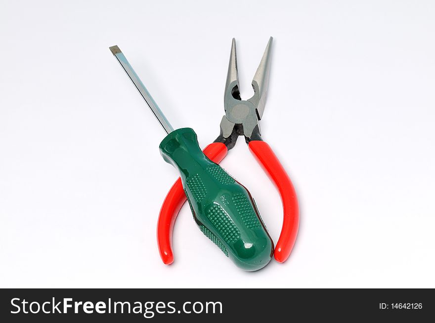 Red handle pliers and screwdrive on a white background . Red handle pliers and screwdrive on a white background .