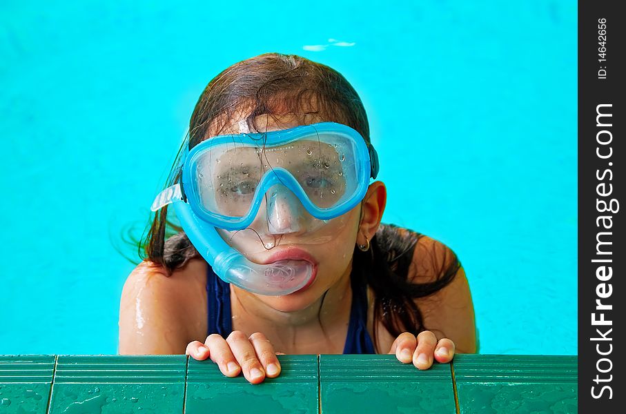 Beautiful girl in a pool with a swimming mask and snorkel