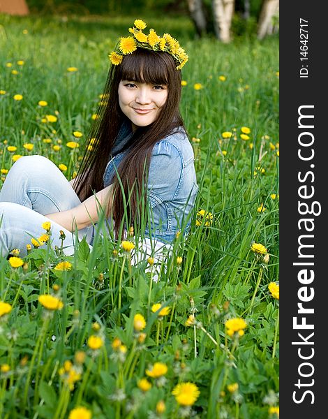 Girl sitting among dandelions