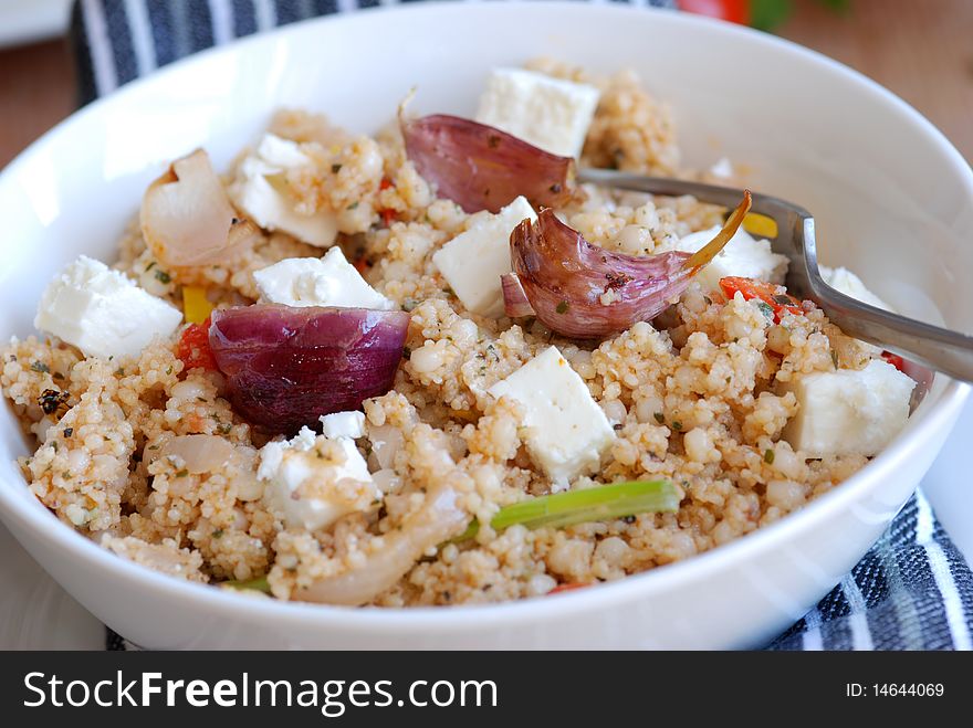 Couscous with feta cheese and vegetables in a bowl. Couscous with feta cheese and vegetables in a bowl
