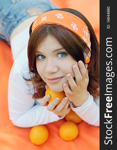 Cute girl with oranges on orange background