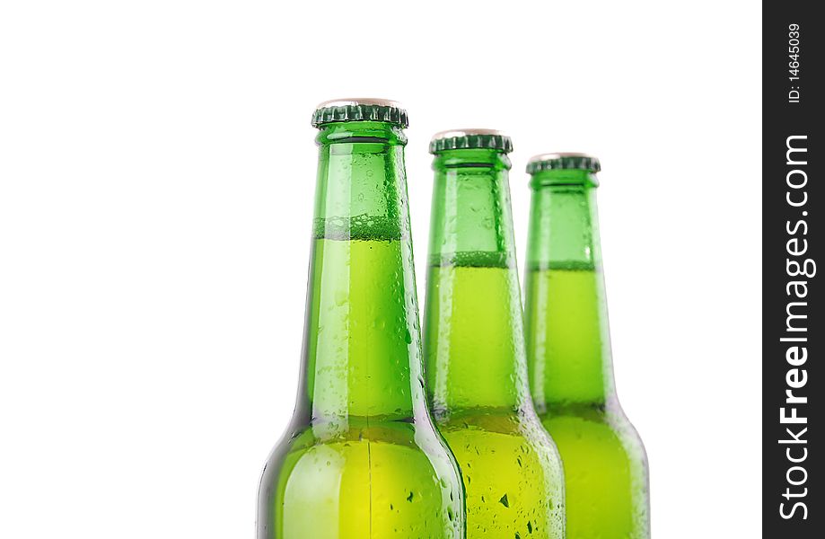 Three beer bottles with water drops on white