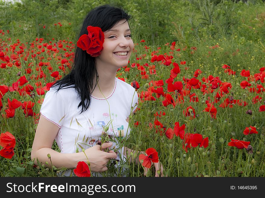 Happy Beautiful Brunette Girl in Red Poppies Field