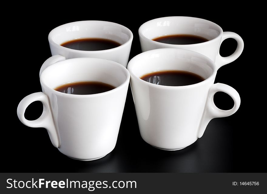Four white coffee cups isolated on a black background. Four white coffee cups isolated on a black background