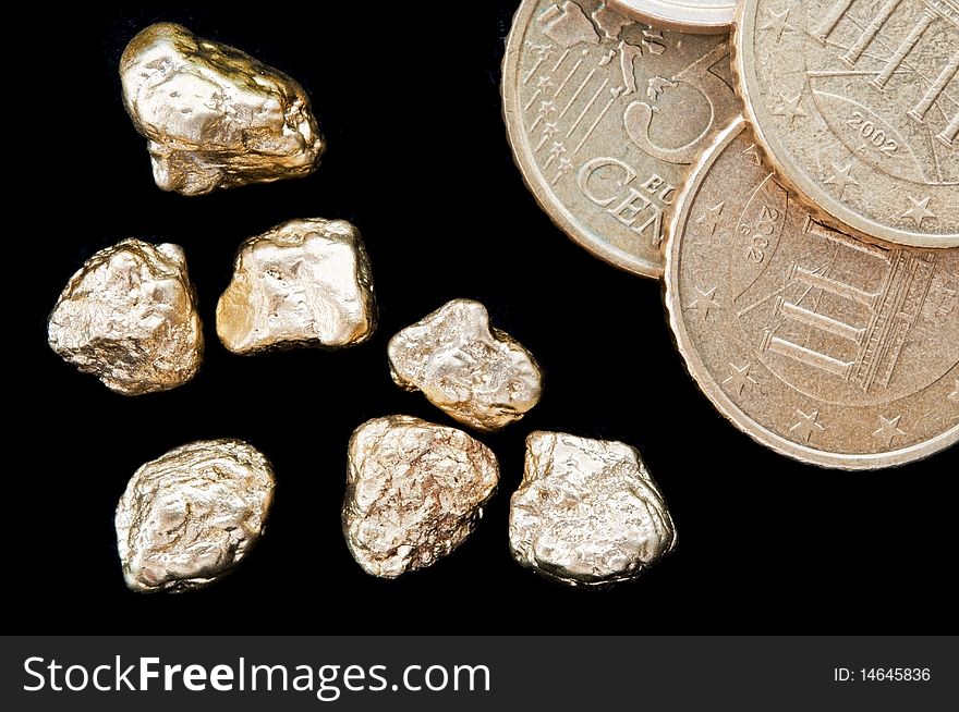 Gold nuggets and money, euro coins on a black background. closeup.