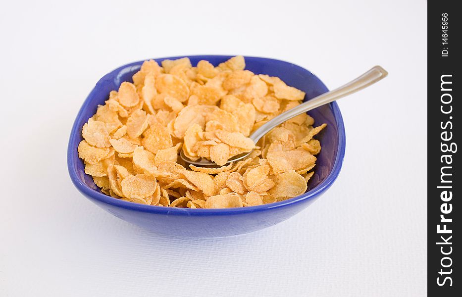 Cornflakes in the blue plato with spoon. Cornflakes in the blue plato with spoon.