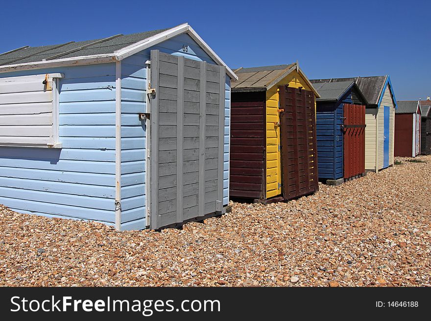 A row of locked beachhuts on a pebble beach in England