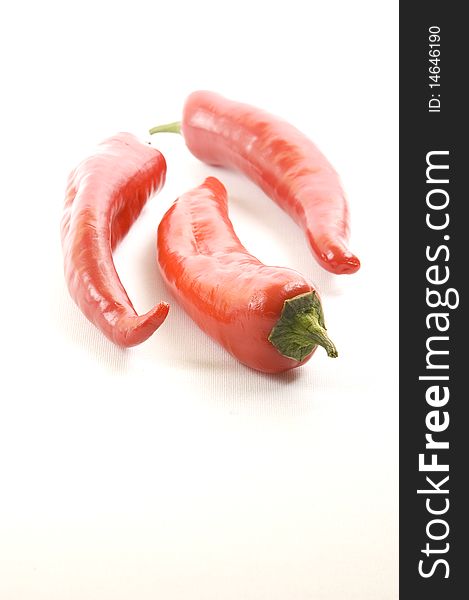 Three red hot chili peppers on a white background.