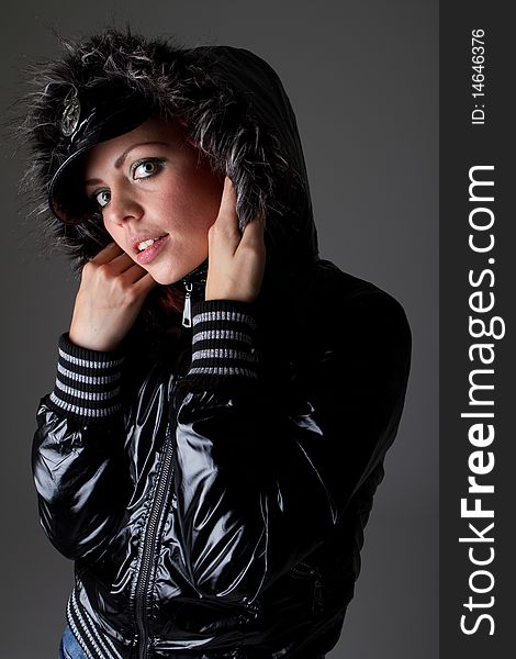 Young fashion model over dark background. She is wearing warm outfit. Very sexy. Young fashion model over dark background. She is wearing warm outfit. Very sexy.