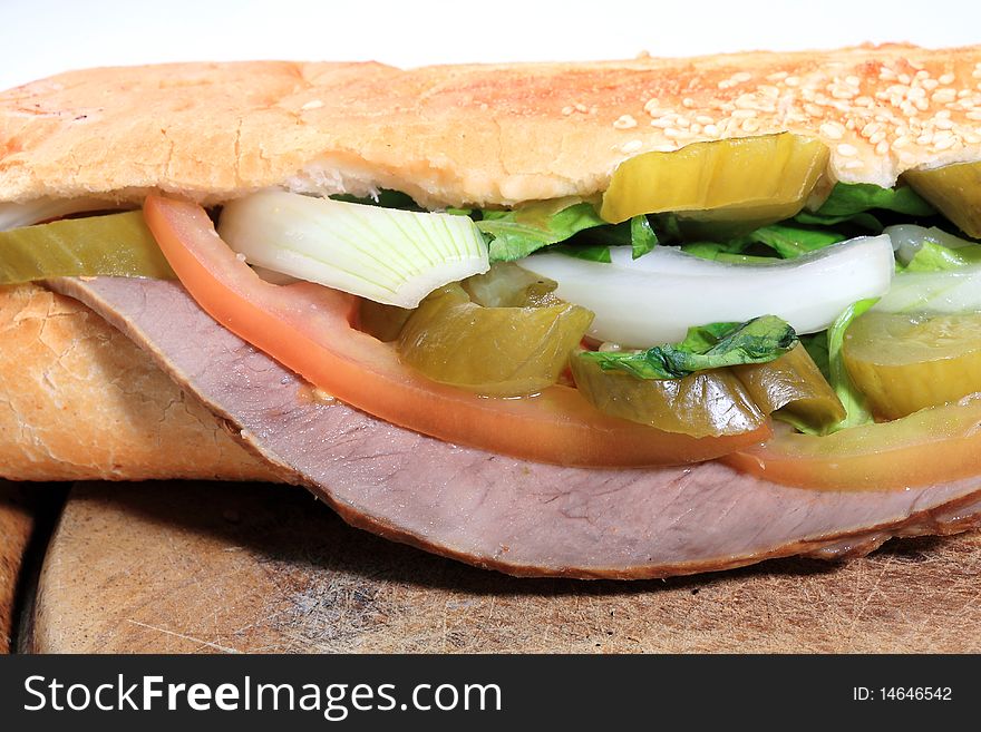 Close up salami sandwich with pickles tomato