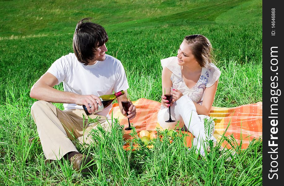 Girl and boy with wine on grass