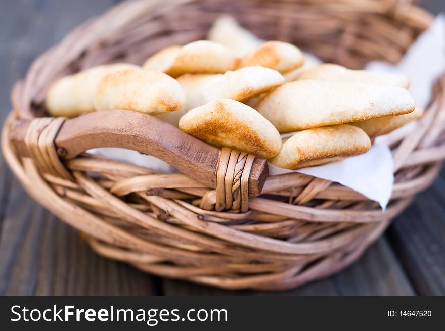 Closeup of  fresh pastry in a wicker basket on wood boards. Closeup of  fresh pastry in a wicker basket on wood boards