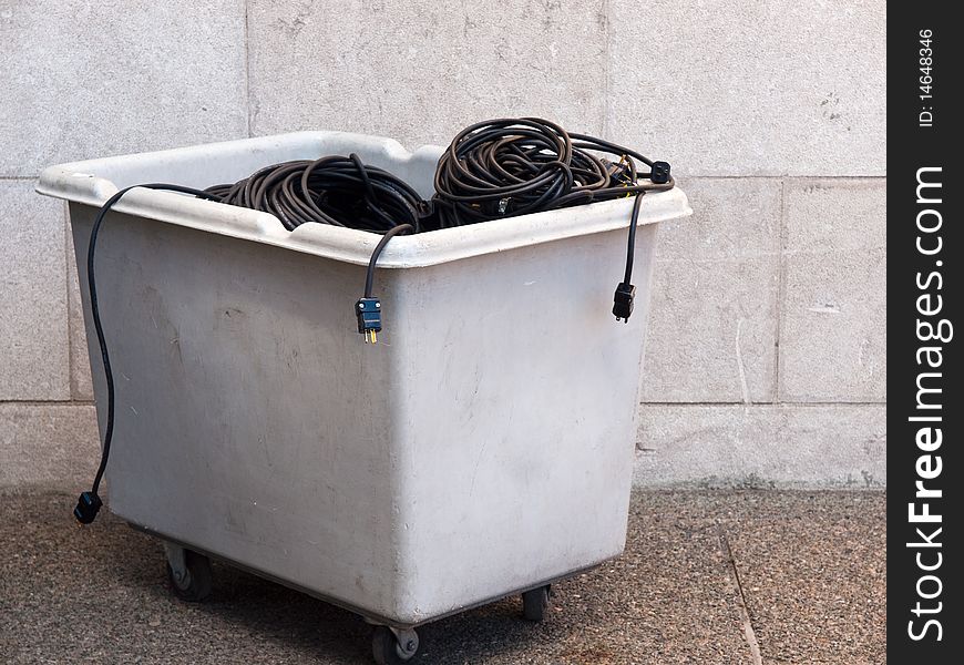 Large plastic bin filled with coiled electrical extension cords. Large plastic bin filled with coiled electrical extension cords