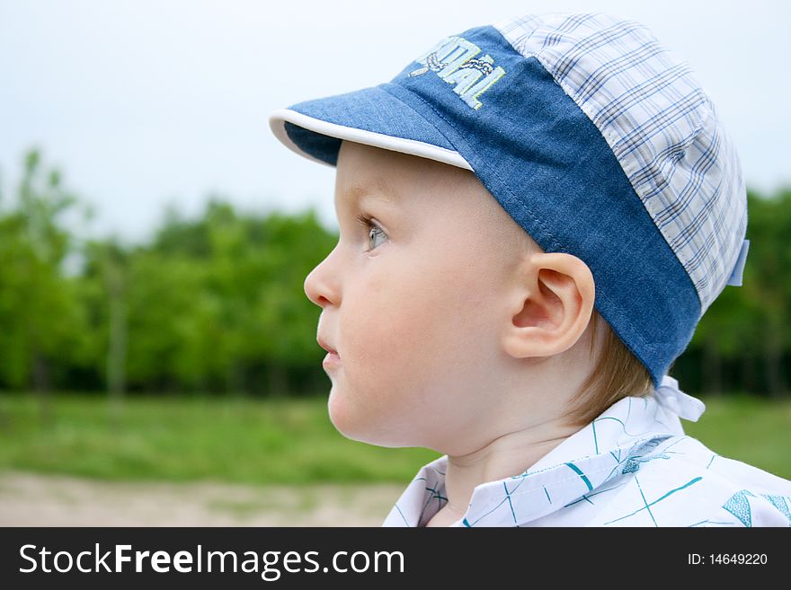 Little boy in the cap and green background