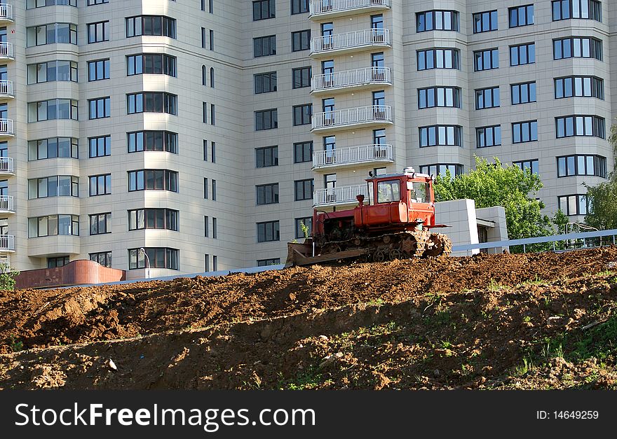 Heavy buildind tractor in front of building site , Moscow, Russia