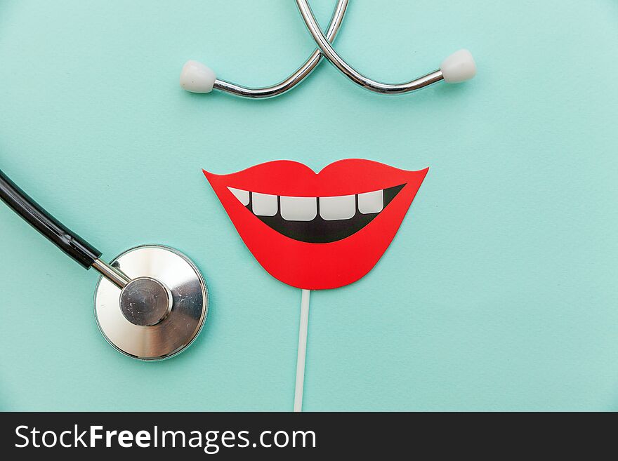 Health dental care concept. Medicine equipment stethoscope or phonendoscope sign of smile teeth  on trendy pastel blue