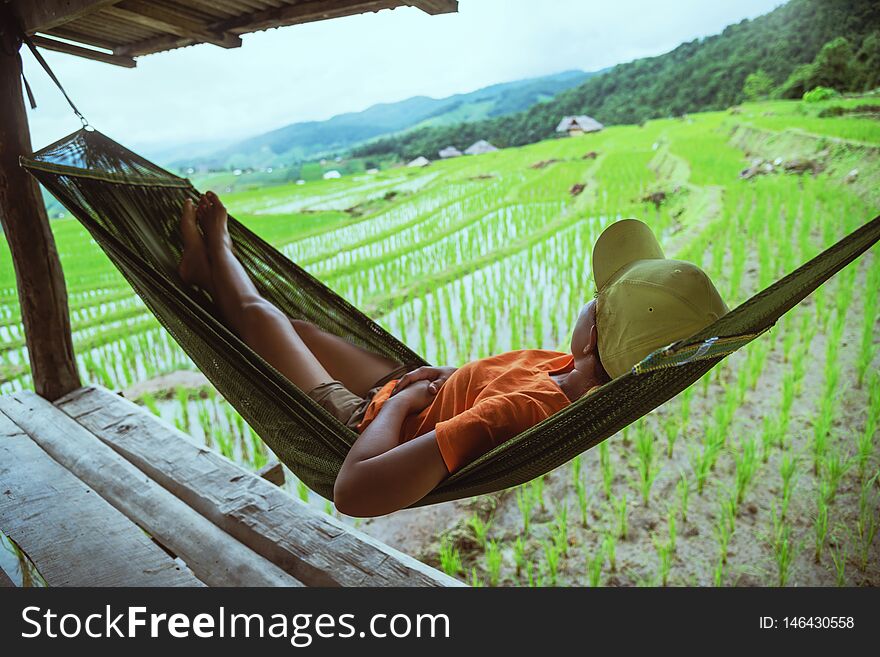Asian woman travel nature. Travel relax. Relax in the hammock the balcony of the resort. View of the field on the Moutain in