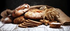 Assortment Of Baked Bread And Bread Rolls On Rustic White Bakery Table Background Royalty Free Stock Photography