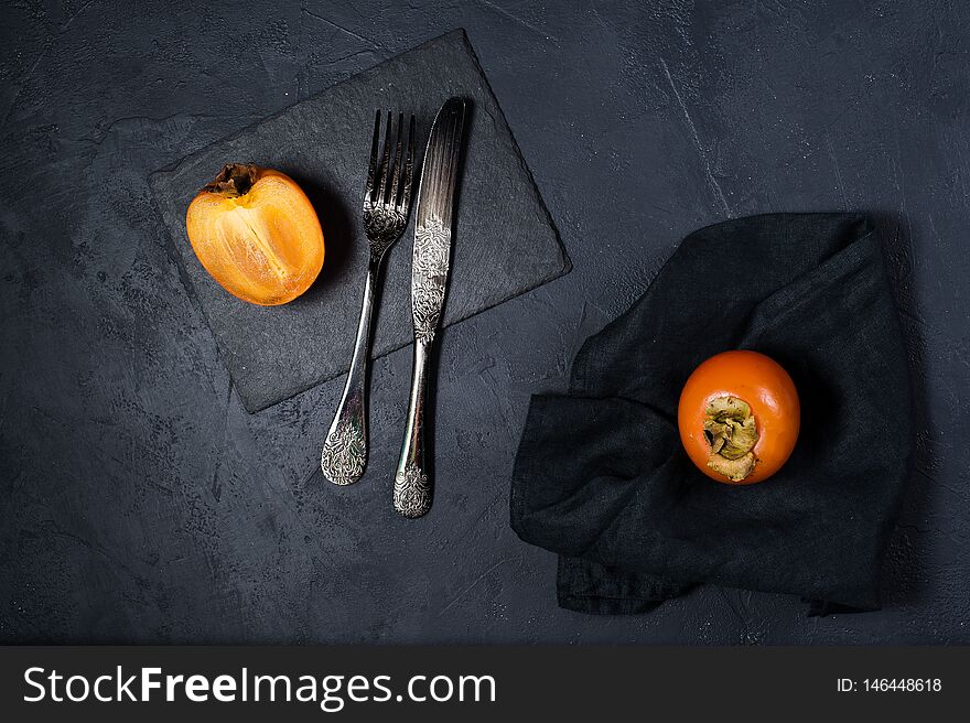 Healthy dessert - persimmon on a black background.