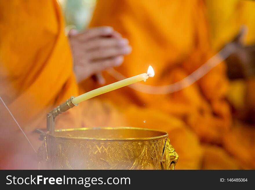 Buddha monk hold candlestick above holy water bowl. religion ceremony.