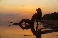 Silhouette Sexy Girl In Swimsuit Lying And Posing On Surf Board At Beach During Sunset Stock Photography