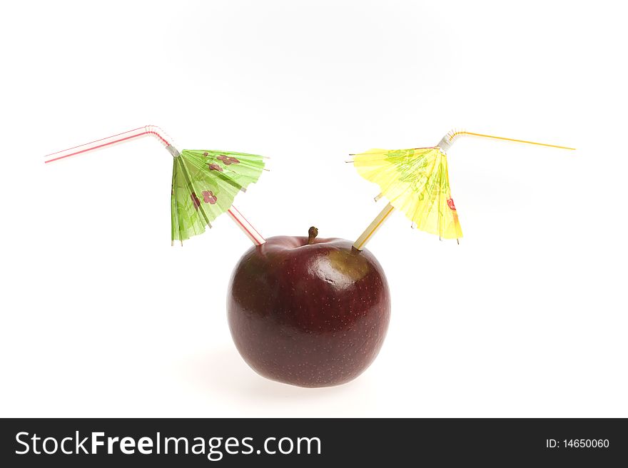 Red apple with two straws and umbrellas isolated