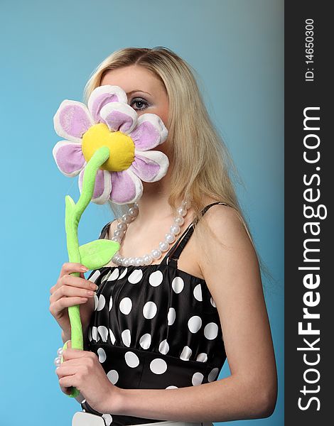 Girl with a toy flower. Studio shot