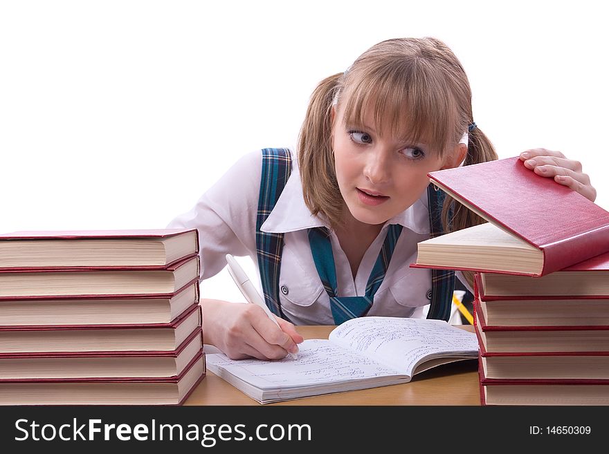 Girl studying hard for exams. Young and beautiful schoolgirl is wearing a traditional uniform watch furtively at the textbook. Girl studying hard for exams. Young and beautiful schoolgirl is wearing a traditional uniform watch furtively at the textbook.