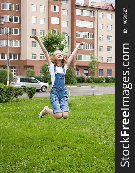 Young happy teenager is jumping outside. Girl is jumping in town