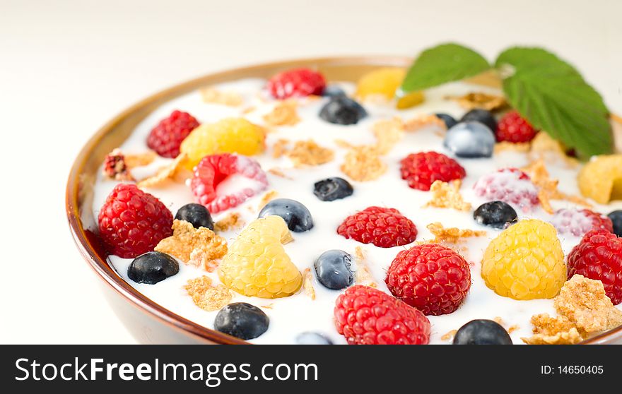 Bowl of granola cereal with raspberries, blueberries and milk. Bowl of granola cereal with raspberries, blueberries and milk