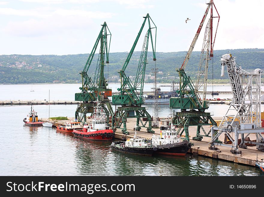 A port with tugboats and cranes. A port with tugboats and cranes